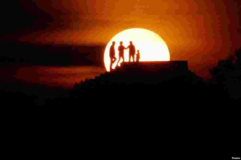 People enjoy the sunset in Vlora, Albania, May 4, 2022.