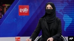 Khatereh Ahmadi a TV anchor, wears a face covering as she reads the news on TOLO NEWS, in Kabul, Afghanistan, May 22, 2022. 