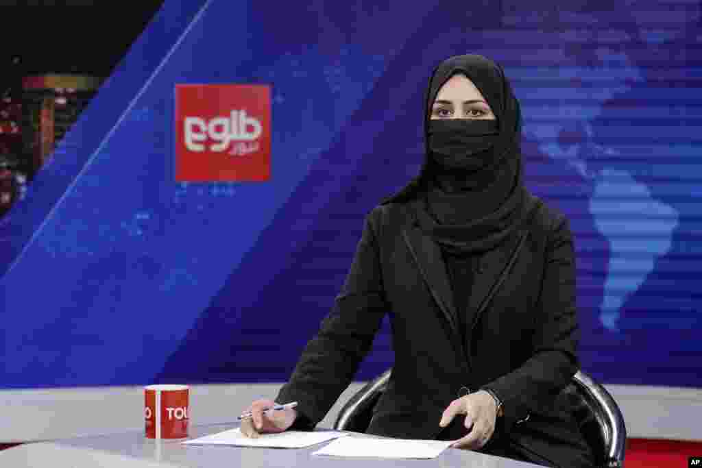 Khatereh Ahmadi a TV anchor, wears a face covering as she reads the news on TOLO NEWS, in Kabul, Afghanistan. Taliban rulers have begun enforcing an order requiring all female TV news anchors in the country to cover their faces while on-air.