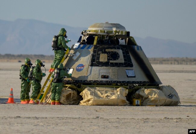 In this handout image, courtesy of NASA, Boeing and NASA teams work around Boeing's CST-100 Starliner spacecraft after it landed at White Sands Missile Rangs Space Harbor, May 25, 2022, in New Mexico. (Photo by Bill INGALLS / NASA / AFP)