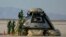 FILE - In this handout image courtesy of NASA, Boeing and NASA teams work around Boeing's CST-100 Starliner spacecraft after it landed at White Sands Missile Range's Space Harbor, May 25, 2022, in New Mexico.