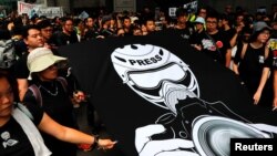 FILE - Journalists and supporters for press freedom wear black as they stage a silent march to police headquarters to denounce media treatment during a protest against a proposed extradition bill, in Hong Kong, China, July 14, 2019. 