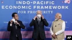 El primer ministro de Japón, Fumio Kishida, a la izquierda, y el presidente de Estados Unidos, Joe Biden, se quitan las mascarillas, junto al primer ministro de India, Narendra Modi, en el acto de presentación del Marco Económico Indopacífico por la Prosperidad, en la Galería del Jardín de Izumi, en Tokio, el lunes 23 de mayo de 2022 en Tokio. (AP Foto/Evan Vucci)