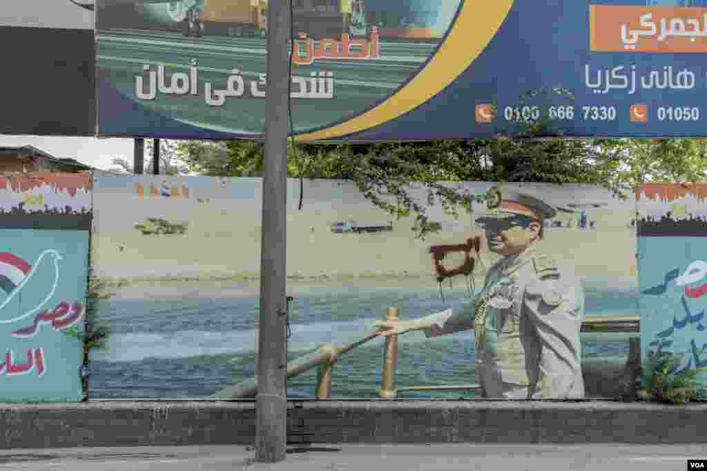 A campaign poster left over Egypt's 2018 presidential election still hangs on the Suez corniche, showing Egyptian President Sisi in military attire during the opening ceremony of the new Suez Canal corridor. (Hamada Elrasam/VOA)