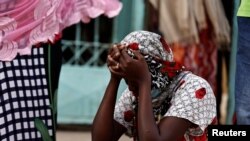 The mother of a 10-day-old baby reacts as she sits outside the hospital, where newborns died in a fire at the neonatal section of a regional hospital in Tivaouane, Senegal, May 26, 2022. 