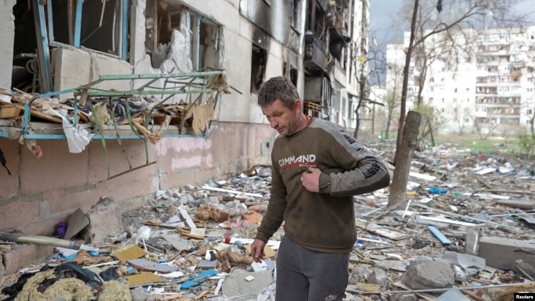 FILE - A local man walks on debris of a residential building damaged by a military strike, as Russia's attack on Ukraine continues, in Sievierodonetsk, Luhansk region, Ukraine. April 16, 2022. 