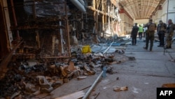 Ukrajinski policajci vrše utvrđivanje stepena razaranja jedne od najveće pijace garderobe "Barabašovo" (na više od 75 hetara), u Harkovu, 16. maja 2022., koja je uništena u bombardovanju tokom ruske invazije na Ukrajinu.