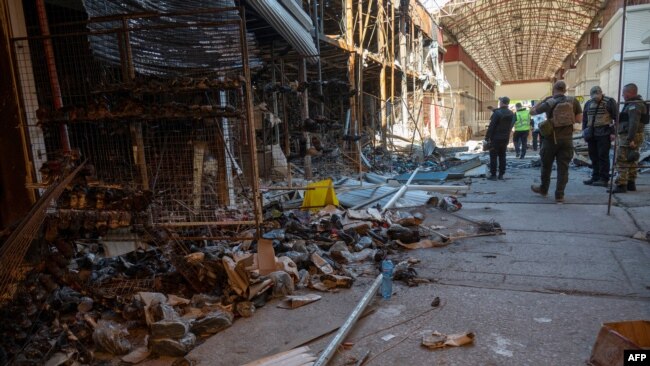 Ukrainian police officers document the destruction at one of Europe's largest clothing markets 'Barabashovo' (more than 75 hectares) in Kharkiv on May 16, 2022, which was destroyed as a result of shelling amid Russian invasion of Ukraine.