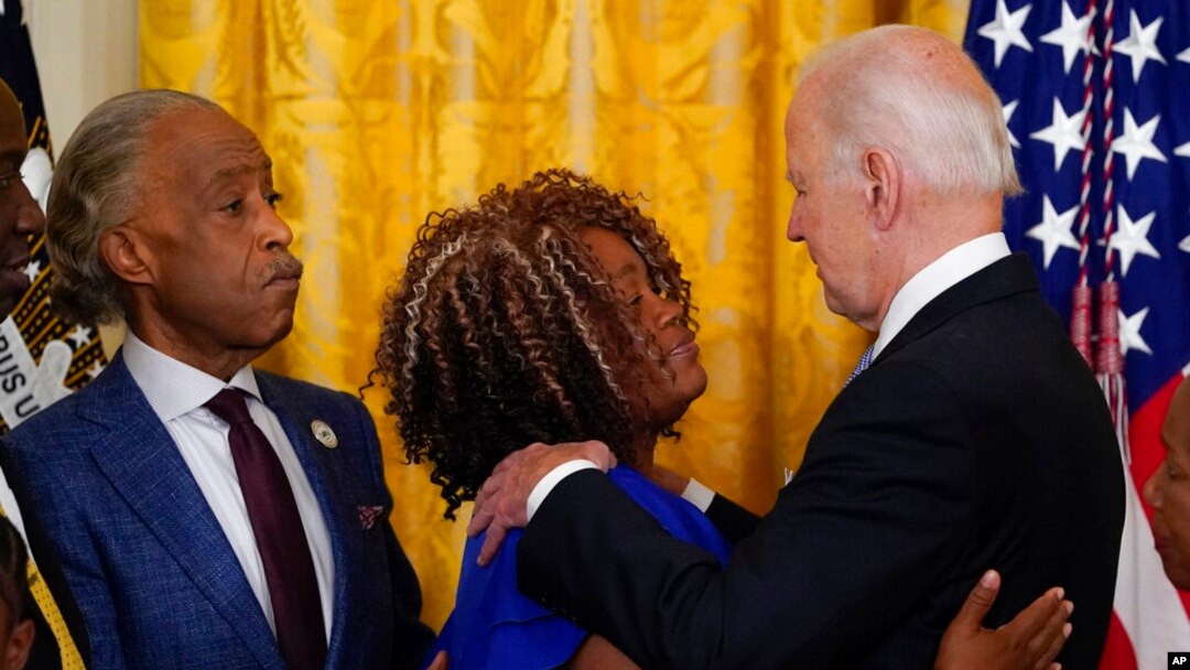 President Joe Biden hugs Tamika Palmer, mother of Breonna Taylor, as the Reverend Al Sharpton watches after Biden signed an executive order on police accountability at the White House, May 25, 2022, in Washington. Taylor, a Black medical worker, was killed by Louisville police in March 2020 during a botched raid on her residence.