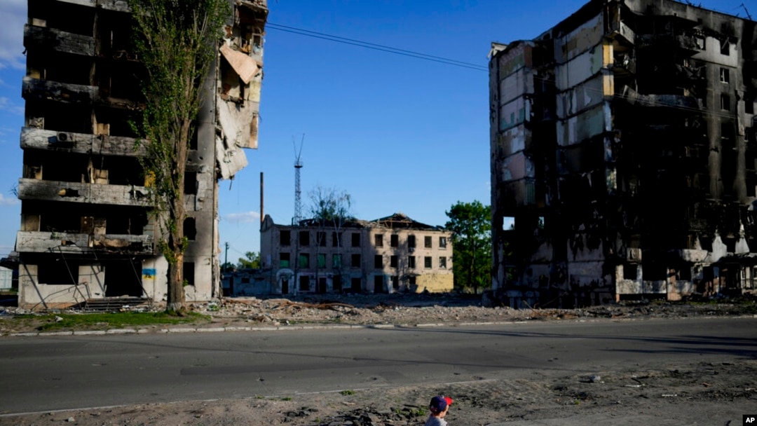 A boy plays in front of houses ruined by shelling in Borodyanka, Ukraine, May 24, 2022. 