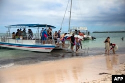 Los turistas desembarcan después de disfrutar de un paseo en bote en Punta Cana, República Dominicana, el 7 de enero de 2022. [AFP]