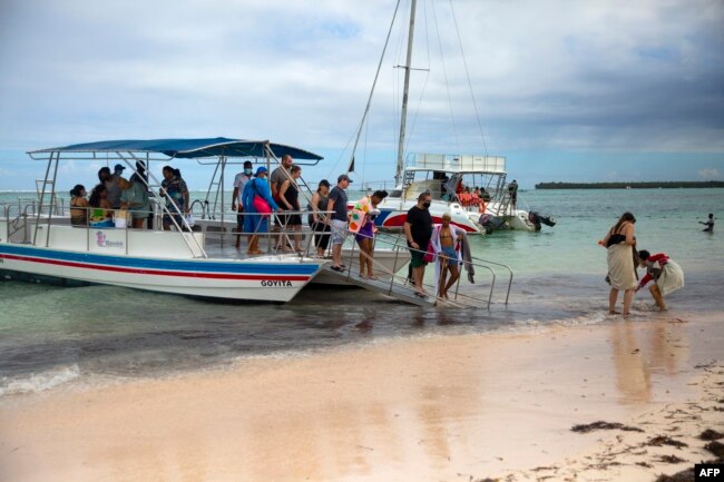 Los turistas desembarcan después de disfrutar de un paseo en bote en Punta Cana, República Dominicana, el 7 de enero de 2022. [AFP]