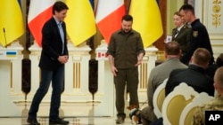 Ukrainian President Volodymyr Zelenskyy, center, and Canadian Prime Minister Justin Trudeau, attend an award ceremony for a Ukrainian sapper and his legendary dog Patron in Kyiv, Ukraine, May 8, 2022.