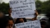 Familiares de personas detenidas durante el estado de emergencia sostienen carteles durante una protesta frente a la Corte Suprema, en San Salvador, el 5 de mayo de 2022.