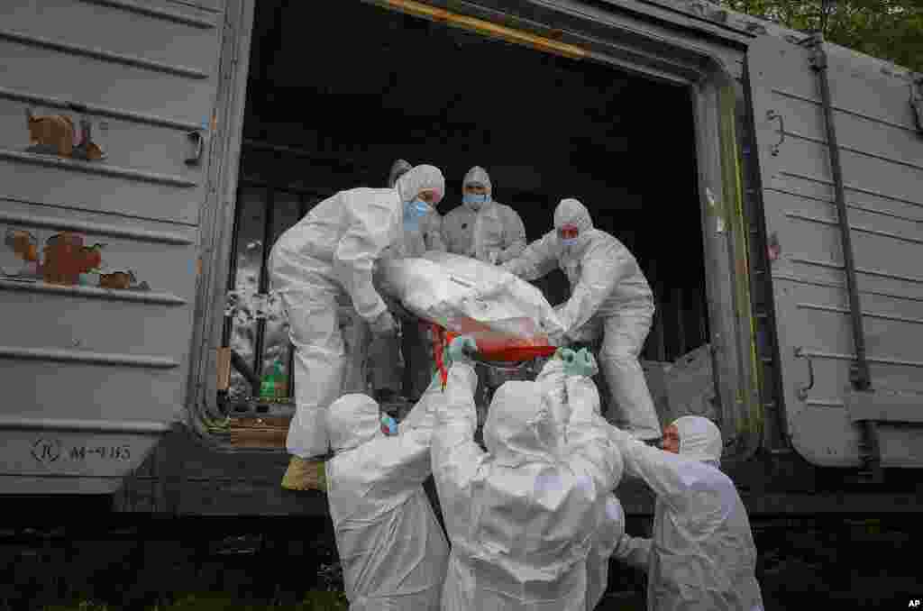 Ukrainian servicemen load bodies of Russian soldiers into a railway refrigerator carriage in Kyiv, Ukraine.