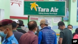 Signage of Tara Airlines is seen above as a team of climbers prepare to leave for rescue operations from the Tribhuvan International Airport in Kathmandu, Nepal, May 29, 2022.