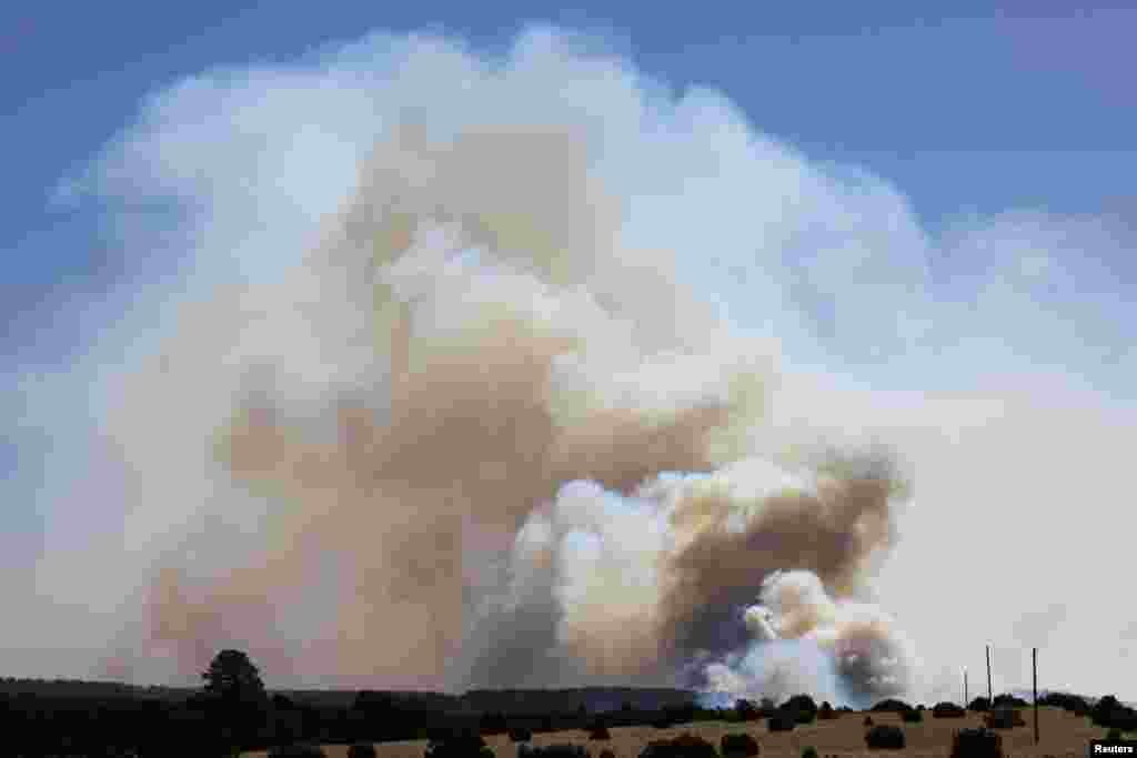 Large plumes of smoke rise from the Hermits Peak and Calf Canyon wildfires, near Las Vegas, New Mexico, May 4, 2022.
