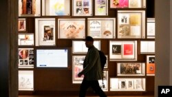 A man walks past a portion of the archive wall at the Bob Dylan Center, May 5, 2022, in Tulsa, Oklahoma. 