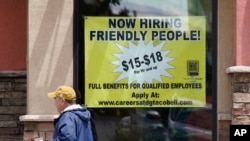 Starting wages are advertised on a sign in the window of a Taco Bell in Sacramento, Calif., May 9, 2022.