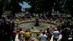 People visit a memorial in a town square to honor the victims of the elementary school shooting earlier in the week, in Uvalde, Texas, May 28, 