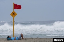 Un hombre descansa en una playa mientras el huracán Agatha avanzaba hacia la costa sur de México, en Puerto Escondido, en el estado de Oaxaca, México, el 29 de mayo de 2022.