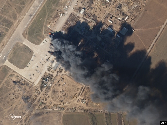 FILE - This Planet Labs satellite image taken on March 15, 2022, shows Kherson air base on fire after an alleged airstrike against Russian forces occupying the base.