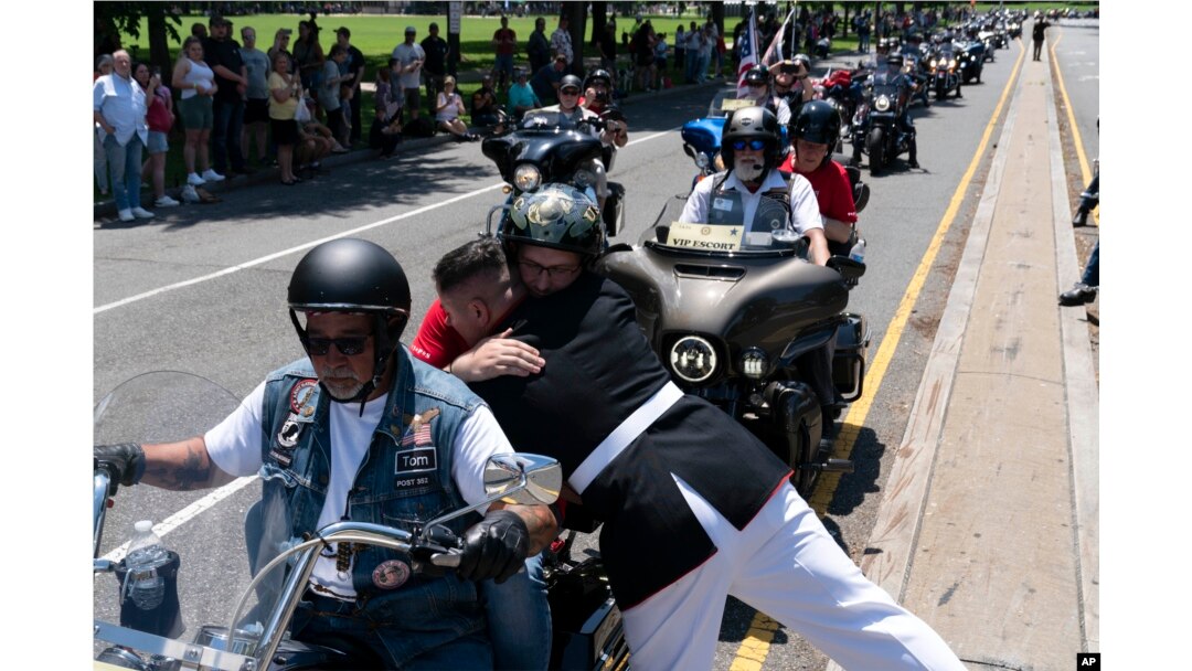 U.S. Marine Corps Staff Sgt. Tim Chambers hugs a participant in the "Rolling to Remember" motorcycle rally on May 29, 2022. Organizers staged the Washington-area ride to spotlight issues facing veterans, demand action for those missing, and raise awareness of the prevalence of suicide among veterans.