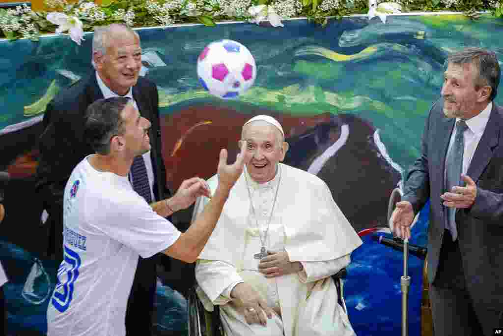 Paus Fransiskus melihat gelandang Argentina Maxi Rodriguez memainkan bola pada peluncuran sekolah &quot;Scholas Occurrentes&quot;, yayasan pendidikan internasional di Universitas Kepausan Urbaniana di Roma. (Foto: AP)