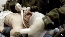 FILE - Yuliia Paievska, known as Taira, and other medical personnel bandage the head of an injured serviceman in Mariupol, Ukraine, Feb. 24, 2022. Using a body camera, Taira recorded her team's frantic efforts to bring people back from the brink of death in Ukraine's war with Russia. (Yuliia Paievska via AP)