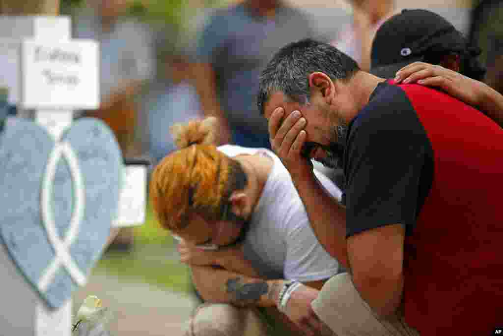 Vincent Salazar, kanan, ayah dari Layla Salazar, menangis sambil berlutut di depan salib dengan nama putrinya di sebuah situs untuk peringatan para korban tewas dalam penembakan sekolah dasar di Uvalde, Texas (27/5). (Foto: AP)