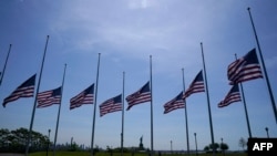 US flags, across New York Bay from the Statue of Liberty, fly at half-mast at Liberty State Park in Jersey City, New Jersey, on May 25, 2022, as a mark of respect for the victims of the May 24, 2022, shooting at Robb Elementary School in Uvalde, Texas.