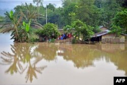 Penduduk desa berlindung di kamp darurat yang dibangun untuk korban banjir setelah hujan lebat di distrik Morigaon, negara bagian Assam, India pada 23 Mei 2022. (Biju BORO / AFP)