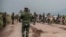 FILE - People walk along a road near Kibumba, north of Goma, Democratic Republic of Congo, as they flee fighting between Congolese forces and M23 rebels in North Kivu, May 24, 2022. 
