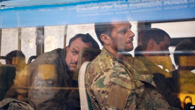 Ukrainian servicemen sit in a bus after they were evacuated from the besieged Mariupol Azovstal steel plant, near a remand prison in Olyonivka, in territory under the government of the Donetsk People's Republic, eastern Ukraine, May 17, 2022. (AP Photo/Alexei Alexandrov)