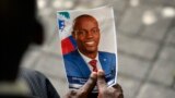 FILE - A person holds a photo of late Haitian President Jovenel Moise during his memorial ceremony at the National Pantheon Museum in Port-au-Prince, Haiti, July 20, 2021.