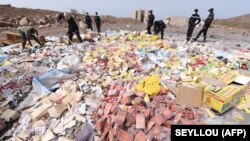 FILE: People work to destroy, on April 21, 2015 at the Champ de tir des Mamelles in Dakar, about 4 tons of counterfeit and illegal medicine seized in an operation as part of the fight against pharmaceutical crime, called "Porc-Epic" (porcupine). 