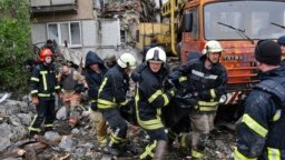 Rescuers carry the body of a civilian at a site of an apartment building destroyed by Russian shelling in Bakhmut, Donetsk region, Ukraine, May 18, 2022.