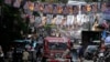 A passenger jeepney passes campaign posters outside a polling center in Manila, Philippines, May 6, 2022. 