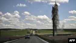 A mortar explodes next to the road leading to the city of Lysychansk in the eastern Ukranian region of Donbas, May 23, 2022, amid Russian invasion of Ukraine. 