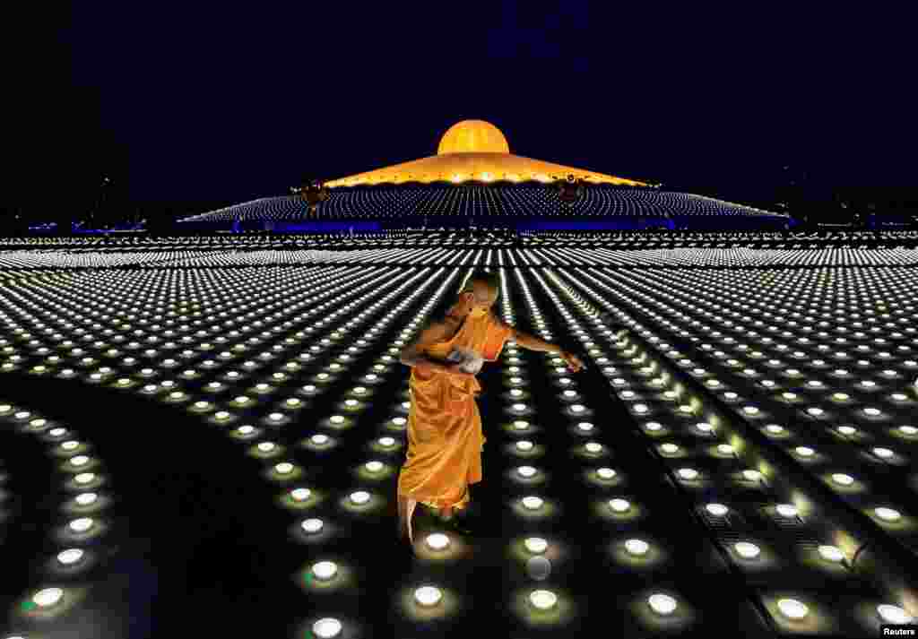 A Buddhist monk places the LED lights as people observe Vesak Day, an annual celebration of Buddha&#39;s birth, enlightenment and death, at Dhammakaya Temple, Pathum Thani, near Bangkok, Thailand.