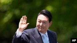 FILE -South Korea's new President Yoon Suk Yeol waves from a car after the Presidential Inauguration outside the National Assembly in Seoul, South Korea, May 10, 2022. This week, he will represent South Korea at the NATO summit in Madrid.