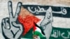 Seorang anak Palestina berjalan membawa bendera di Yerusalem. Palestina akan merayakan Nakba, hari berkabung atas berdirinya Israel pada 1948 setelah perang Arab-Israel membawa perpindahan ratusan ribu dari orang-orang Palestina. 