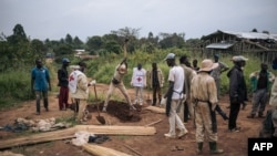 ARCHIVES - Des volontaires de la Croix-Rouge enterrent les corps de personnes tuées par des miliciens de la Codeco dans le village de Dhedja, le 19 décembre 2021, dans l'Ituri, en République démocratique du Congo. 