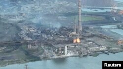 Una vista de una planta de Azovstal Iron and Steel Works dañada durante lluvias de municiones de llamas brillantes, en medio de la invasión rusa de Ucrania, en Mariupol, Ucrania, en esta imagen fija sin fecha obtenida de un video publicado el 15 de mayo de 2022.