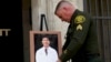 Orange County Sheriff's Sgt. Scott Steinle displays a photo of Dr. John Cheng, a 52-year-old victim who was killed in Sunday's shooting at Geneva Presbyterian Church, during a news conference in Santa Ana, Calif., May 16, 2022. 
