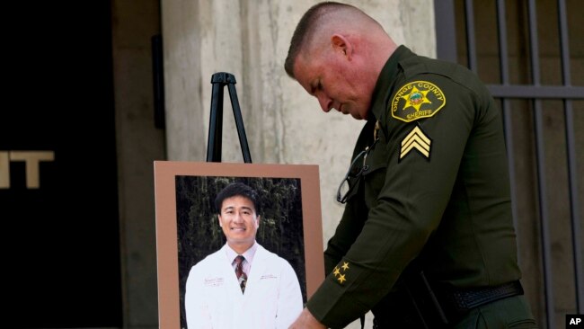 Orange County Sheriff's Sgt. Scott Steinle displays a photo of Dr. John Cheng, a 52-year-old victim who was killed in Sunday's shooting at Geneva Presbyterian Church, during a news conference in Santa Ana, Calif., May 16, 2022.