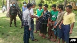 Officials talk to survivors from a boat that left from Rakhine state but capsized, in Pathein district, about 200km west of Yangon, in this photo taken May 22, 2022, and received May 24, 2022, courtesy of an anonymous source.