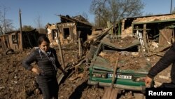 ယူကရိန်းနိုင်ငံ Bakhmut မြို့မှာ ရုရှားဒုံးကျည်နဲ့ တိုက်ခိုက်မှုကြောင့် ပျက်စီးသွားတဲ့ နေအိမ်ကို ကြည့်ရှုနေတဲ့ အမျိုးသမီးတဦး။ (မေ ၇၊ ၂၀၂၂)