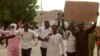 Des manifestants portent des pancartes indiquant "Non à la France" alors qu'ils participent à une manifestation anti-française à N'Djamena le 14 mai 2022.