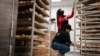 FILE - Madina Safi, 28, top, trains Marjan Enayt, 18, who is also a recent refugee from Afghanistan, as they work in a grocery store bakery in Virginia, April 14, 2022. 